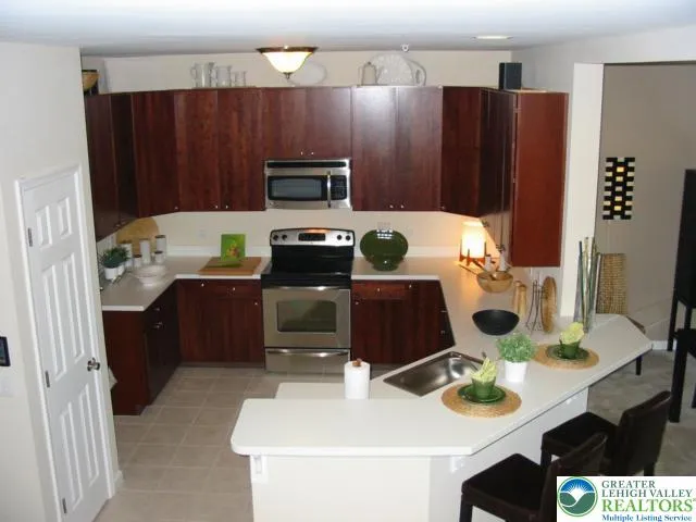 Large open kitchen featuring 42" Armstrong Cabinets, Ceramic Tiled floor, large breakfast bar and enough countertop space to please the chef in your family.