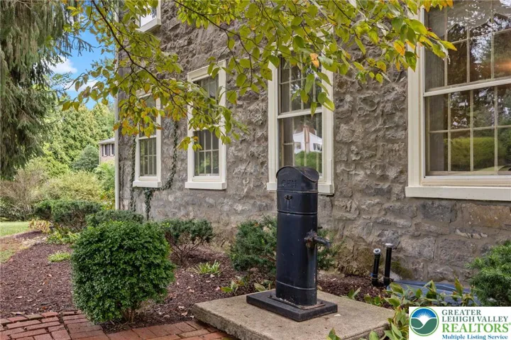 Stone facade with vintage well pump.