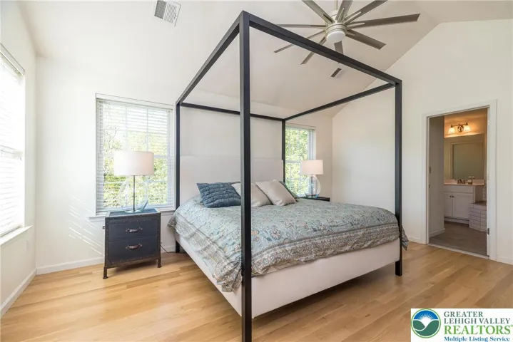Primary bedroom with ceiling fan/light combo and hardwood floors