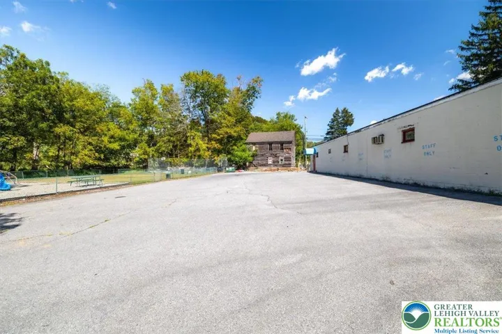 West side of building with large parking area for more than 20 vehicles