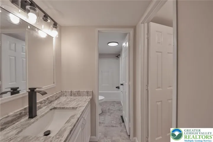 Primary Bathroom features new vanity, counters and flooring.