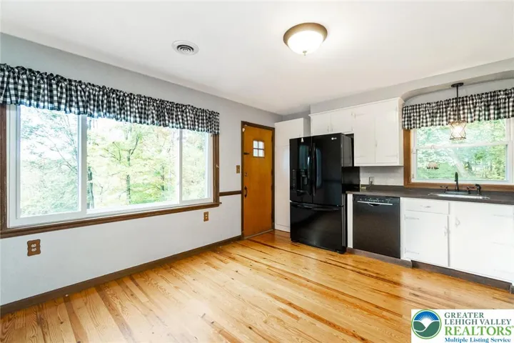 Kitchen with French door fridge and dishwasher and side door to deck