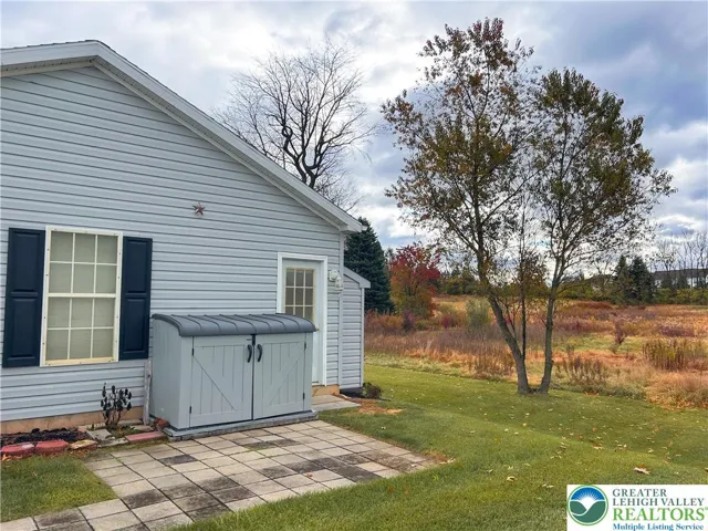 Brick patio and shed outside of garage.