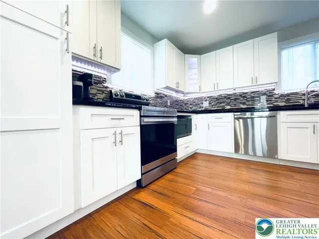 Custom cabinets provide plenty of storage, including tall uppers and deep drawers that make the kitchen both practical and beautifully organized.