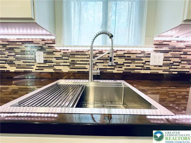 Modern stainless steel sink with matching faucet and sleek backsplash tile for a clean, updated look.