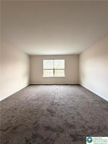 Primary bedroom featuring a walk-in closet and private en suite bath.