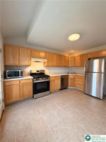 Kitchen with stainless steel appliances, open to the main living areas.
