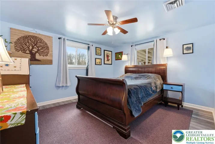 Primary Bedroom with light / fan & hardwood floors