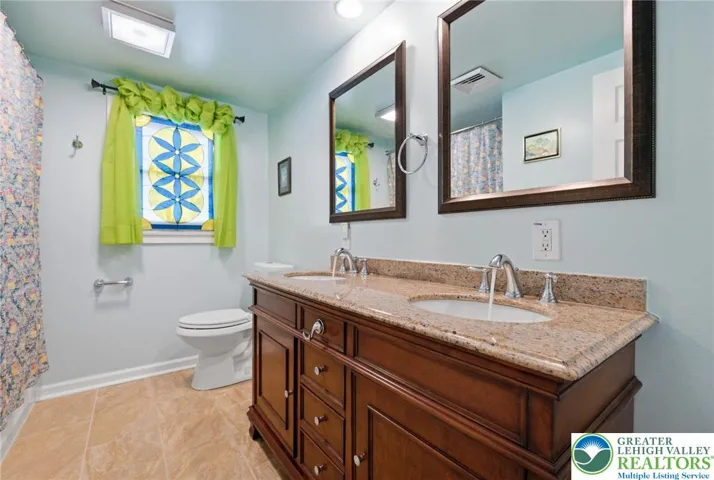 Bathroom with dual vanities, large tile floor