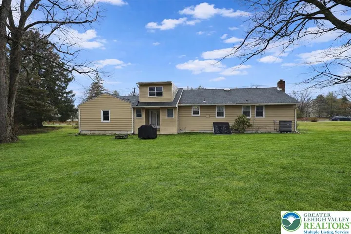 Back of home with large private backyard