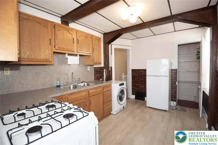 2nd floor unit full kitchen features gas cooking, pantry closet, formica counter tops, and  a convenient washer