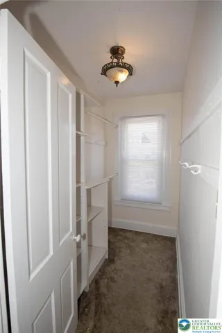 another walk in closet with custom shelving in the units