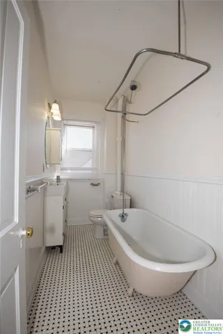 full bath with claw foot tub and tile floor