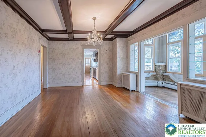 Dining room with coffered ceiling opens to sitting area