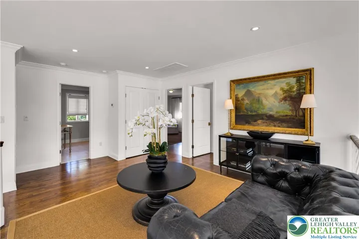 Loft at the top of the staircase with hardwood floors, abundant natural light, and versatile space for seating, a study nook, or play area.