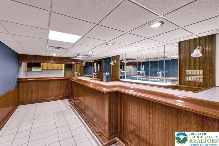 Fully finished lower level — an entertainer’s dream: pub-style bar with keg system, commercial-grade kitchen, full bath with jacuzzi, built-in seating throughout, and three flexible rooms suitable as a bedroom, playroom, office or storage. Ideal for hosting, recreation, and multi-function use.