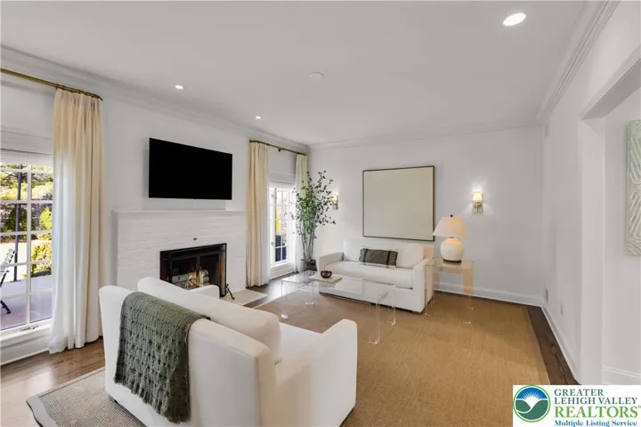 family room with hardwood flooring and a wood-burning fireplace with gas hookup for easy conversion—flexible, cozy space for gatherings.