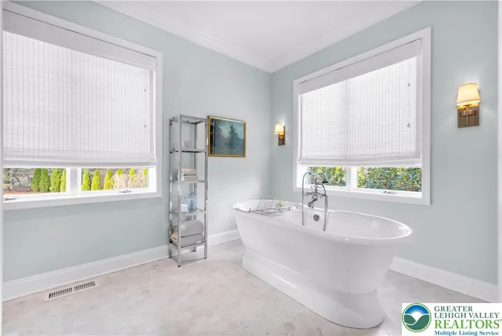 
Spa-style bath with Carrara marble flooring, dual shower heads, and a deep soaking tub—an elegant, private retreat with premium finishes