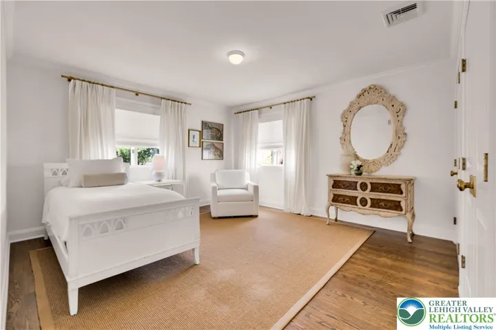 
Large bedroom with hardwood flooring and closets featuring built-in storage—spacious, organized, and bright.