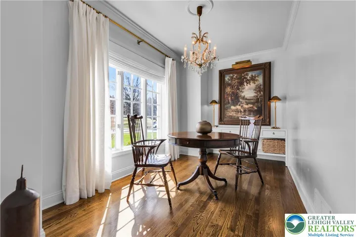 Office/den with rich hardwood flooring and custom built cabinetry