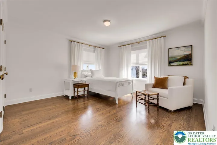 
Large bedroom with hardwood flooring and closets featuring built-in storage—spacious, organized, and bright.
