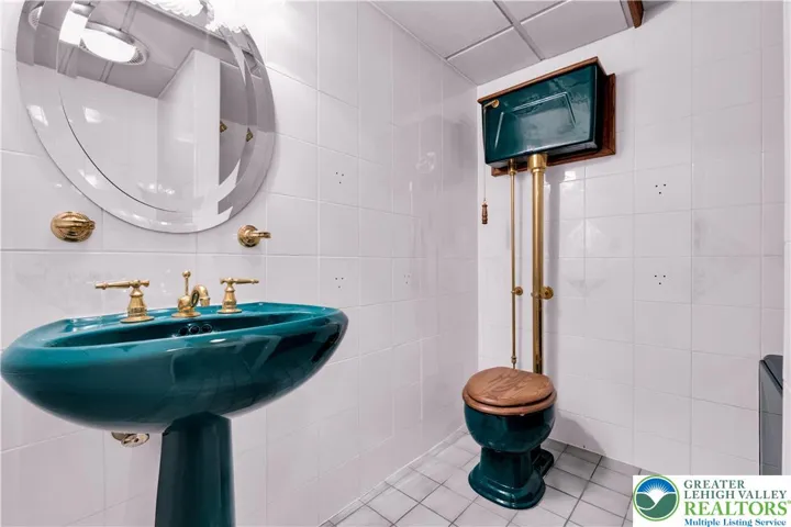 
Retro-style full bath in the basement featuring a Jacuzzi tub, vintage tile accents, period fixtures, classic vanity, and warm ambient lighting—nostalgic charm paired with modern comfort.