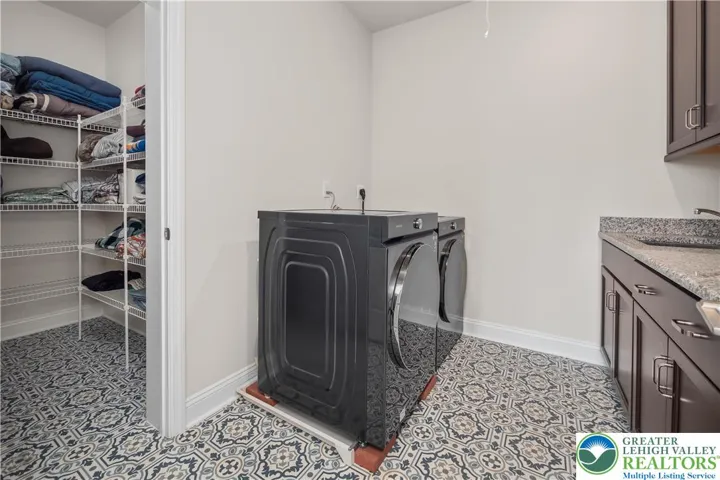 Laundry room with cabinetry, countertop, and storage closet