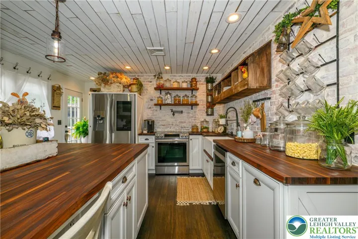 Custom reclaimed shiplap ceiling detail, pendant lights and recessed lighting.