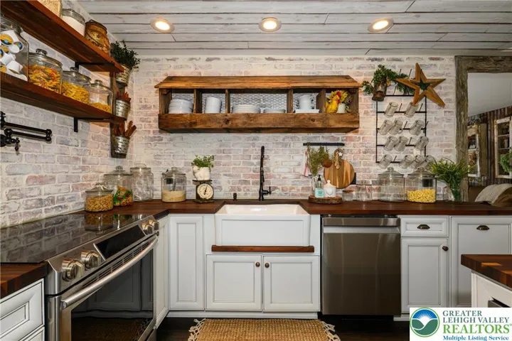 Farmhouse sink, goose-neck faucet and custom open shelving adding function and personality