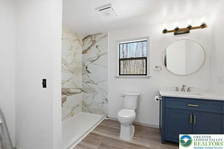 Primary Bathroom with modern finishes including a bluetooth light/fan/speaker.
