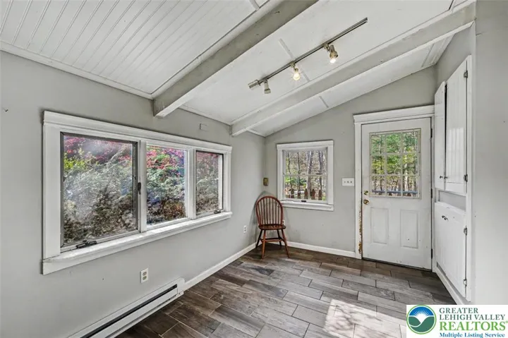 The Dining area is also tiled with a vaulted ceiling, track light with window and door facing the front.
