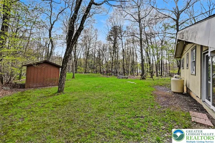 Side view of the back yard with storage shed (Needs replacing).
