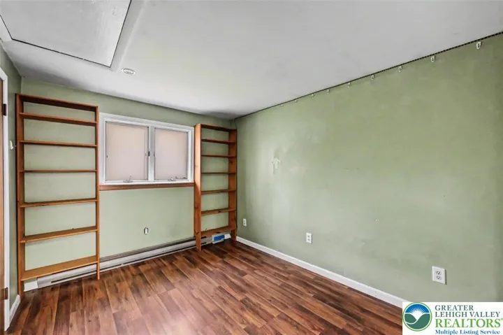 Bedroom 2 has laminate floors, built-in shelves and a double yard-facing window.
