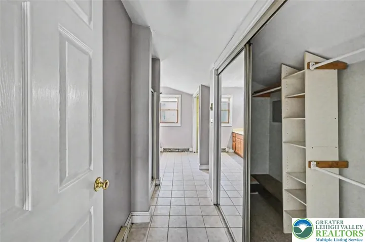 The Primary Bath is spacious with tiled floors, a single shower with glass doors and a walk-in closet with built-in shelving.
