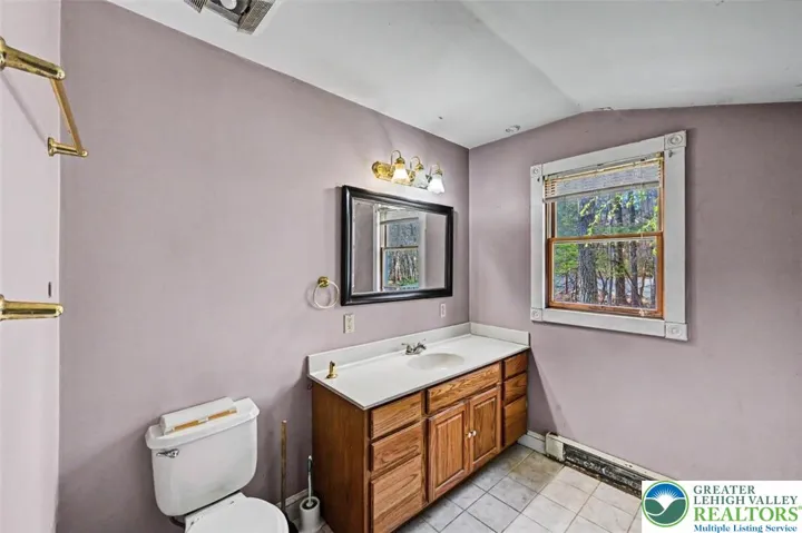 The Primary Bath features a double vanity with single sink, a lighted mirror and front-facing window.
