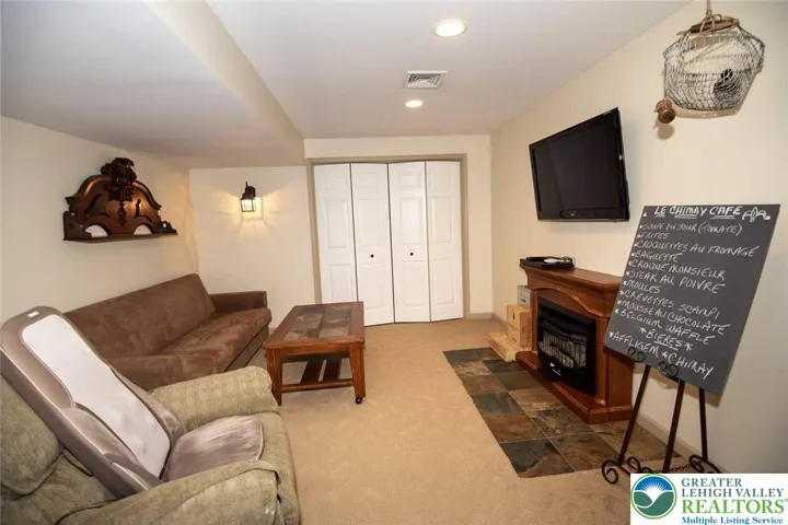 Extra living space with the lower level family room; ventless fireplace and wall TV remain with home