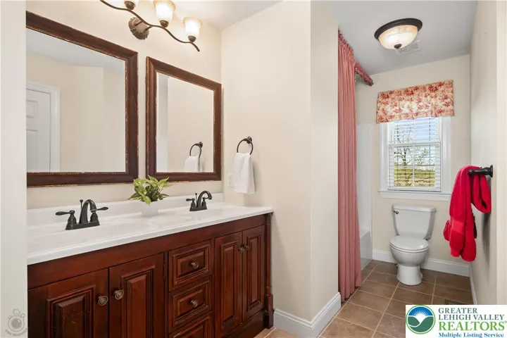 Double sink vanity, ceiling-to-floor custom shower curtain.