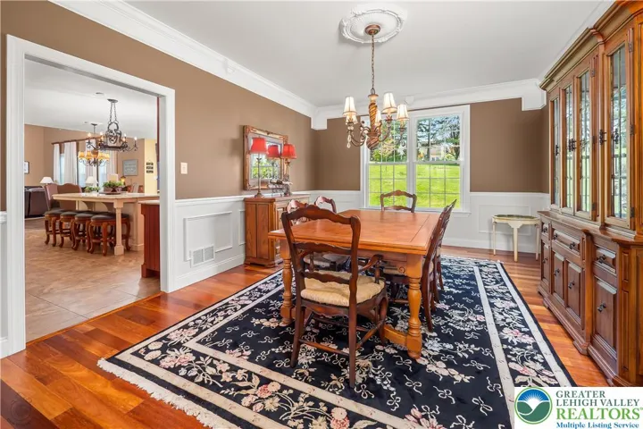 Formal dining room w/beautiful crown moulding and wainscoting can handle a large table.