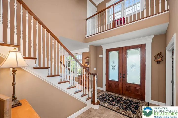 Large open two-story foyer with bridge above door. Great spot for holiday decor.