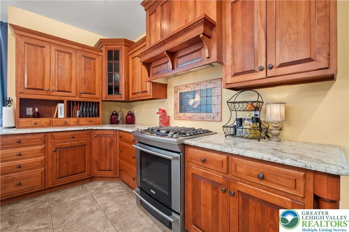Mixed-height cabinets add interest. Plate rack, glass-front cabinets, tile panel at cooktop....