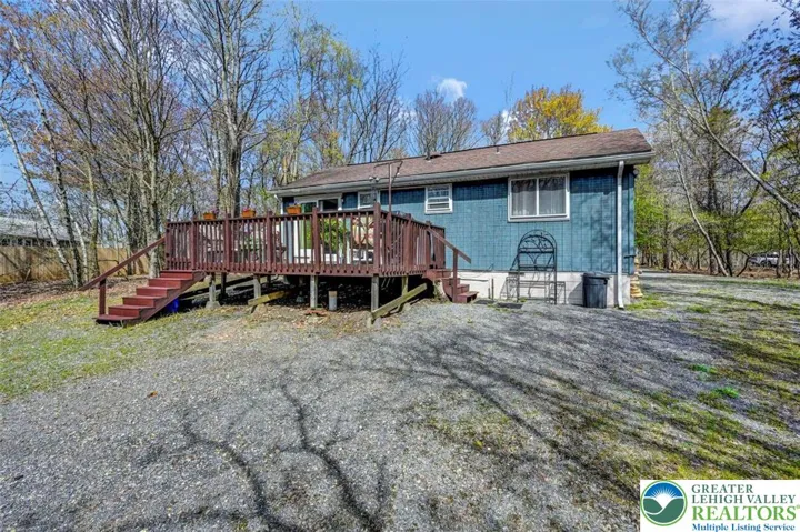 The home sits on a private, flat lot surrounded by mature trees.
