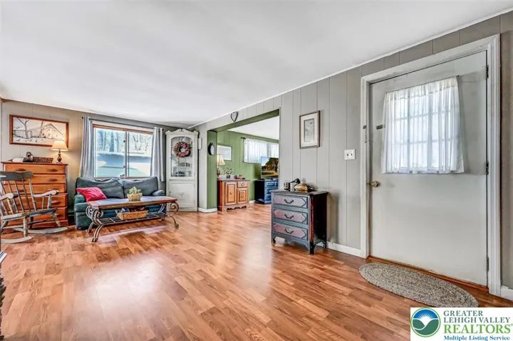 The front door features a storm door and steps into the Living Room.
