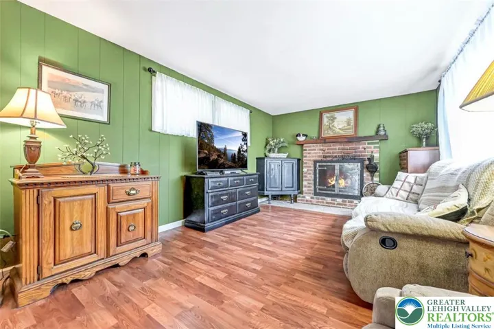 The Family Room is spacious and features a wood burning fireplace with brick surround, a wood mantle and glass doors.
