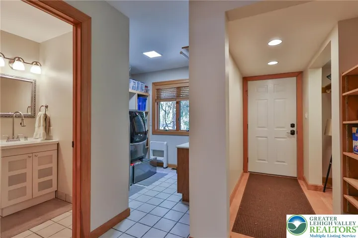 Garage and side door entry foyer facing half bath and laundry room