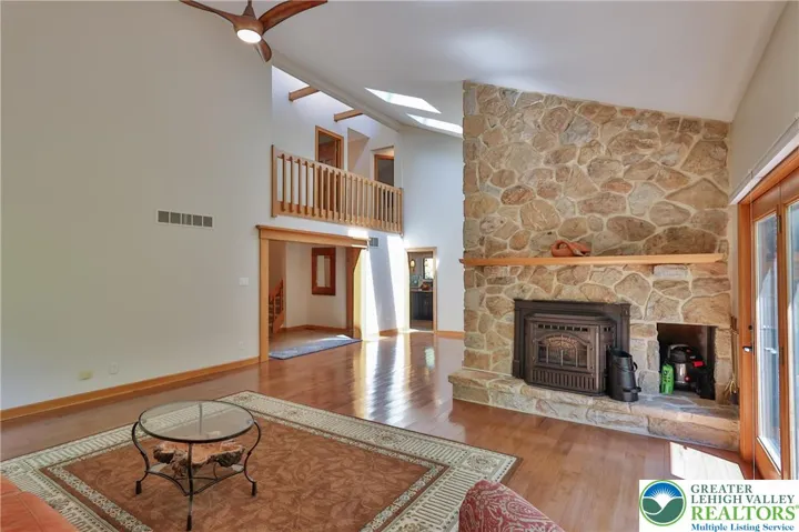 Formal living room features stone fireplace with pellet insert