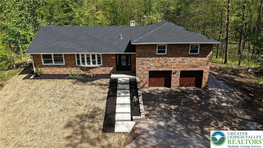 Drone Shot of front of home showing wooded backdrop