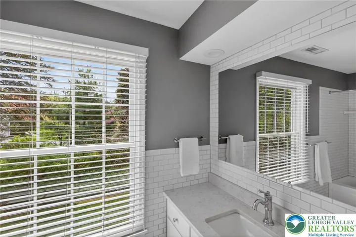 Full Hall Bath with quartz vanity; tiled shower/tub/half wall