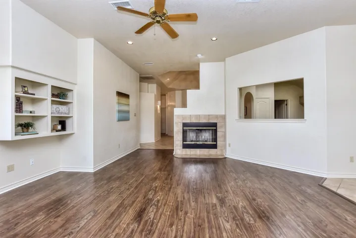 A view of the foyer from the family room.  Wood burning fireplace, bookshelves, and a see-through to the kitchen area.  The wood laminte flooring was juts replaced....