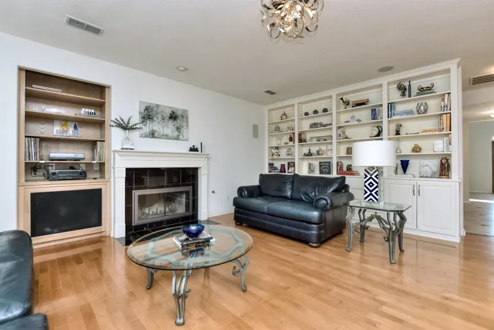 Let's move on to the family room which is so spacious and feels like the perfect place to gather.  With a gas-lit wood burning fireplace.  Speakers for surround sound and a wonderful buitl-in with shelves & cabinets for showing  off your books & prized possessions...