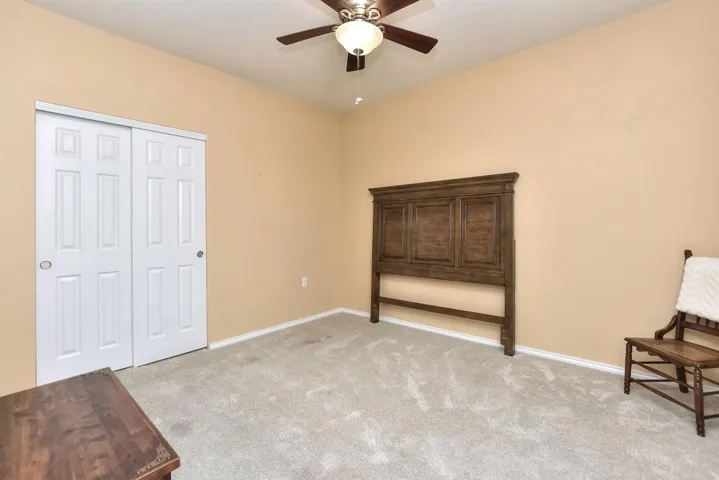 To the right of the front door is the second bedroom with a ceiling fan & a nice sized closet.  This room is the only carpeted room in the home...